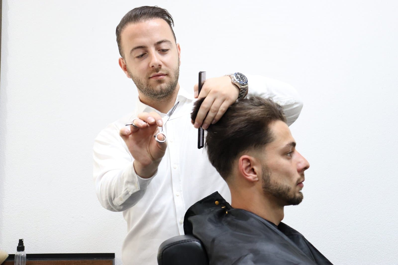 Guney knipt een klant in de salon
